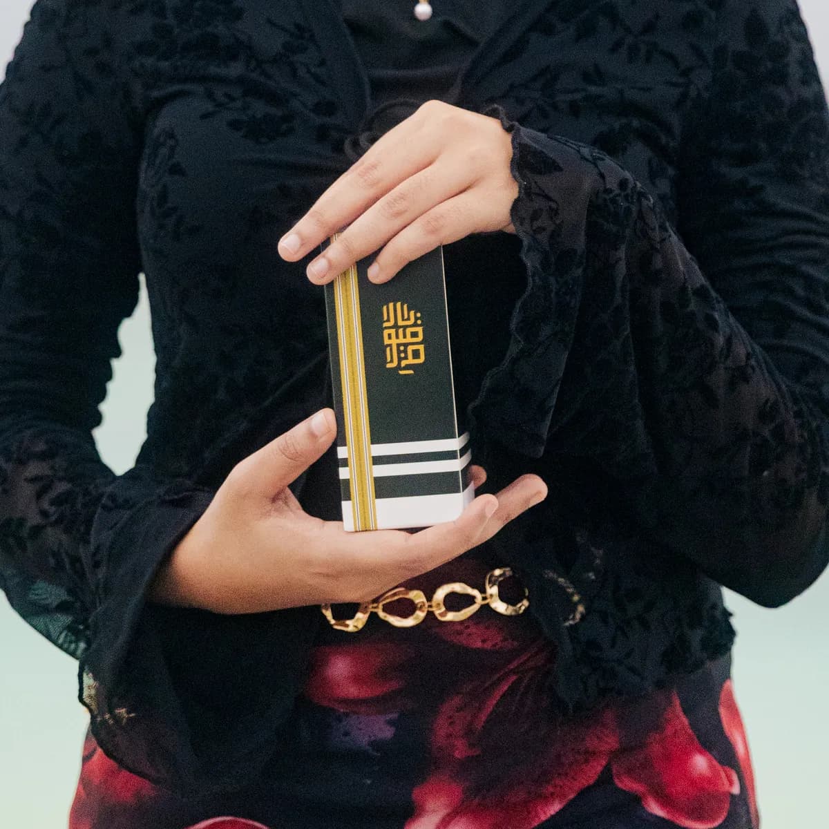 A model in black holding the Barfume gift box