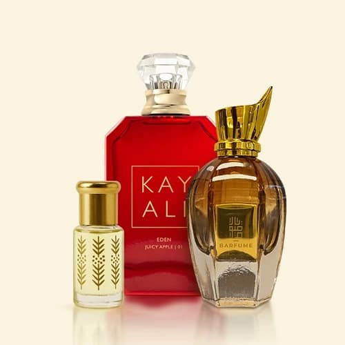 The Kayaali Eden Juicy Apple bottle between a gold attar vial and a Barfume eau de parfum